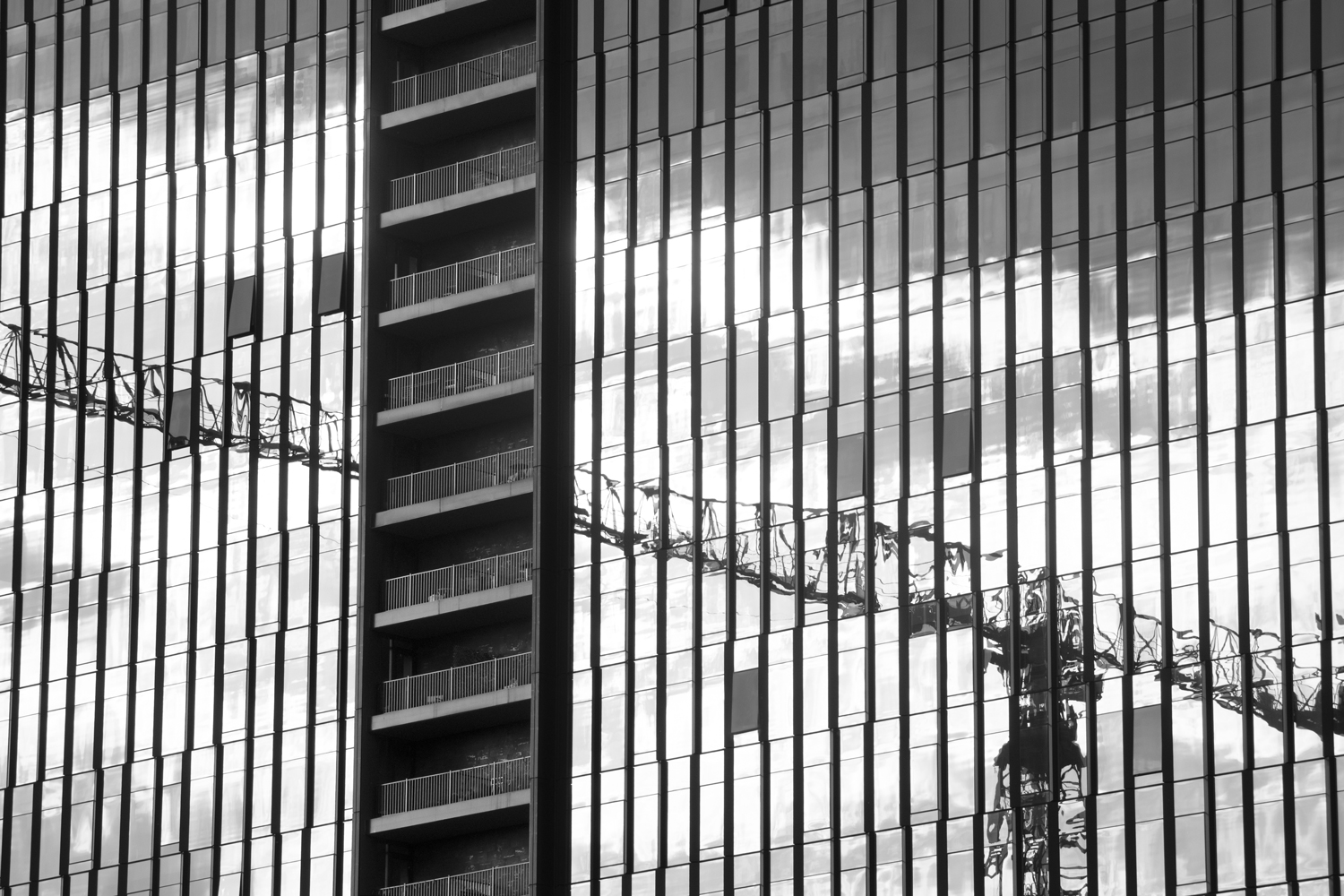 the reflection of a crane off of a skyscraper