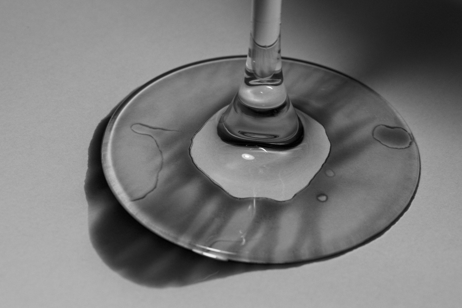 the base of a martini glass with a wet spill underneath