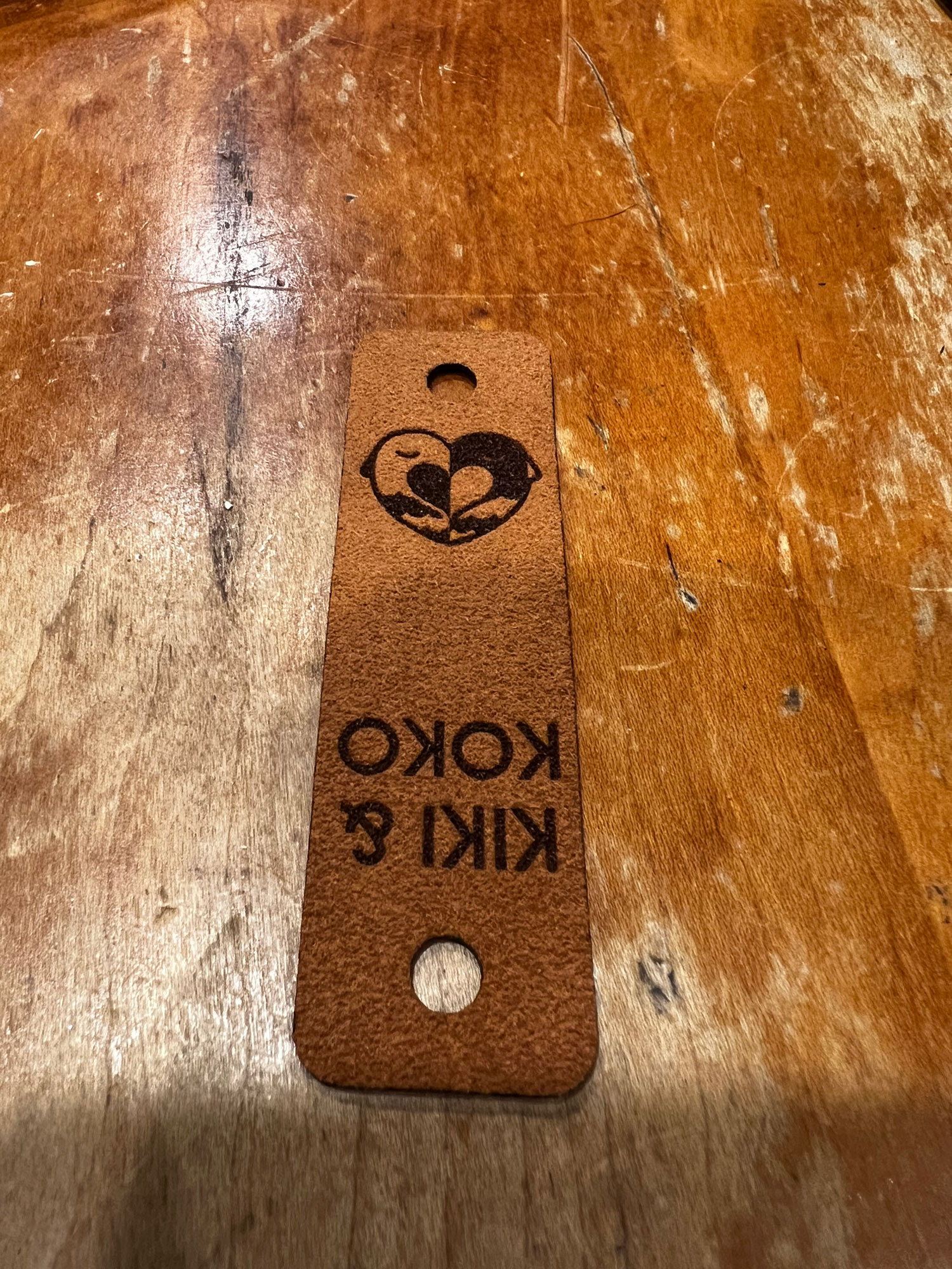 a leather tag with the Kiki & Koko logo burned on to it